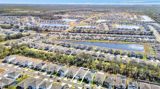 a aerial view of a house with a yard and a lot of flower plants