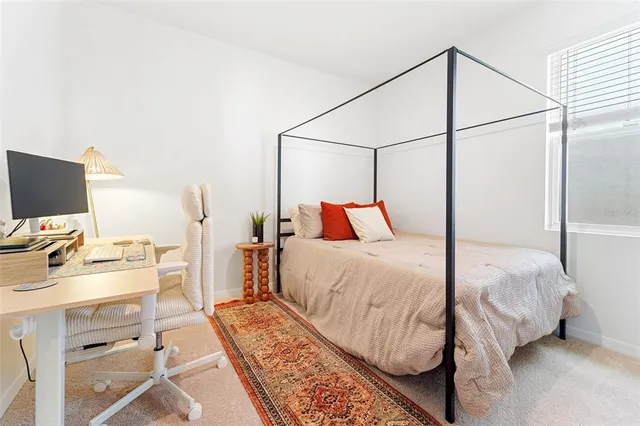 a bedroom with a bed and a flat tv screen on the dresser