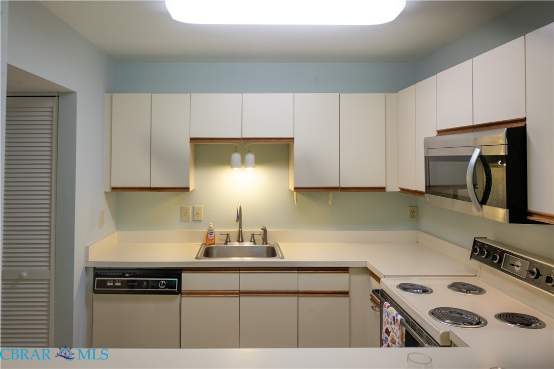 54 Villa Ridge Drive, Unit C Hartfield, VA 23071 - Photo 37 of 45 Kitchen with white appliances, light countertops, and white cabinets