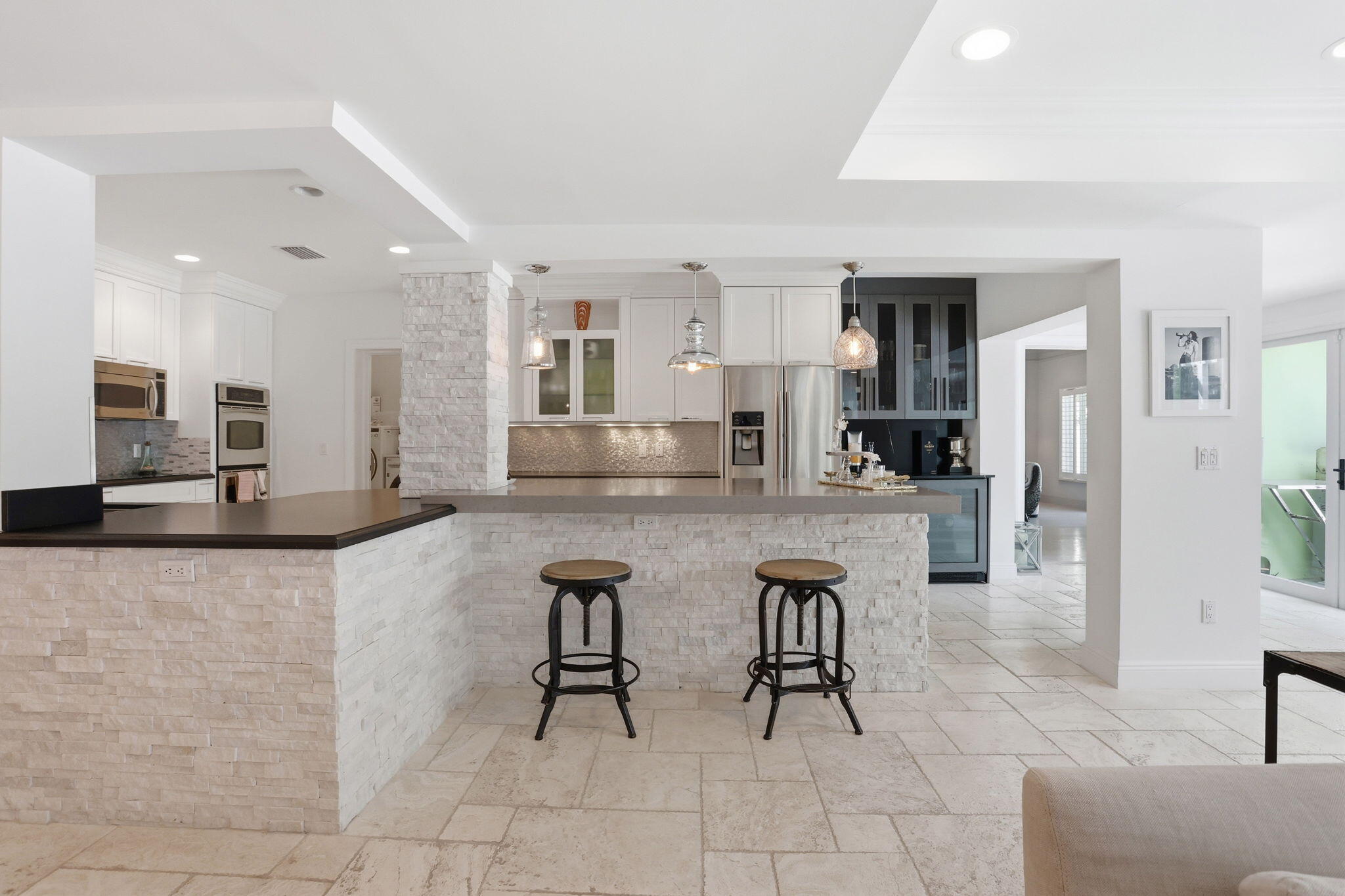 309 Northeast 8th Avenue Delray Beach, FL 33483 - Photo 13 of 43 a large white kitchen with cabinets chairs and a view of living room