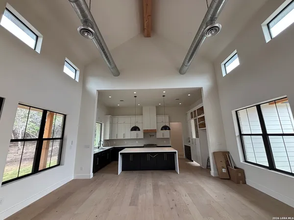 a large white kitchen with a sink stainless steel appliances and cabinets
