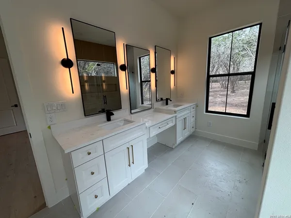 a bathroom with a double vanity sink a mirror and a bathtub