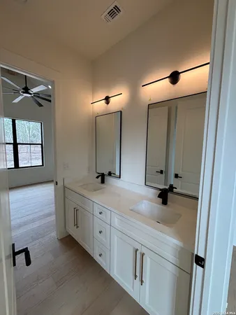 a bathroom with a double vanity sink and mirror