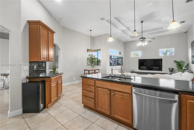 a kitchen with stainless steel appliances granite countertop a sink a stove top oven a counter space and cabinets