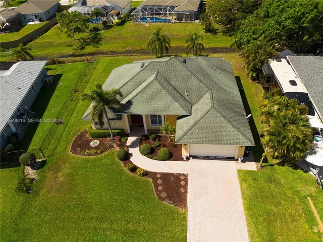 an aerial view of a house with swimming pool garden and lake view