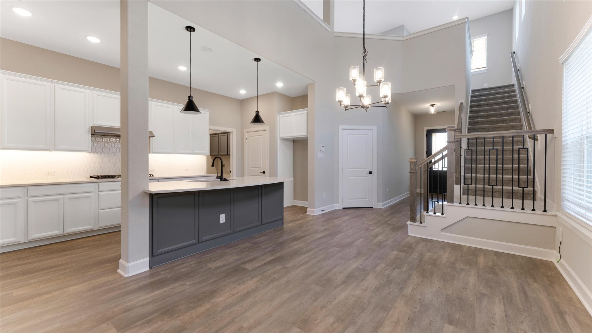 15607 Rising Wren Court Conroe, TX 77302 - Photo 8 of 40 a view of a kitchen with granite countertop stainless steel appliances cabinets a sink and a wooden floor