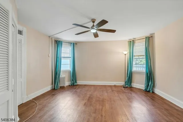 an empty room with wooden floor a ceiling fan and closet