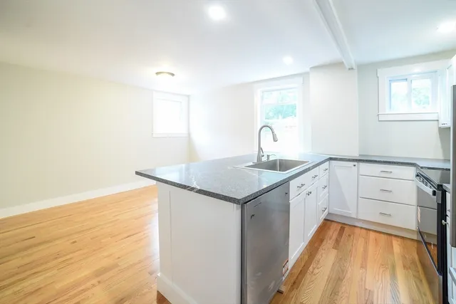 a kitchen with a sink cabinets and wooden floor