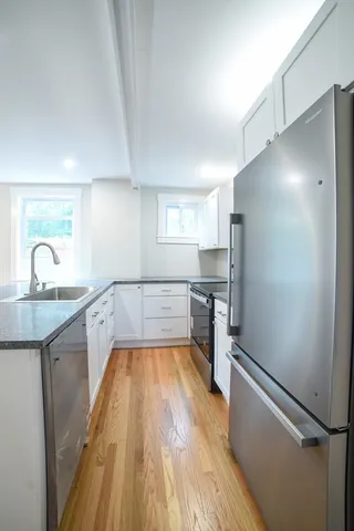 a kitchen with granite countertop a refrigerator and a sink