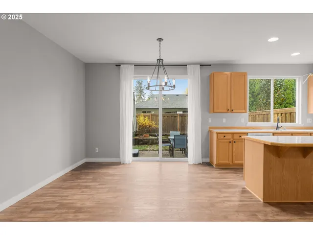 a open kitchen with granite countertop a stove top oven a sink dishwasher and white cabinets with wooden floor