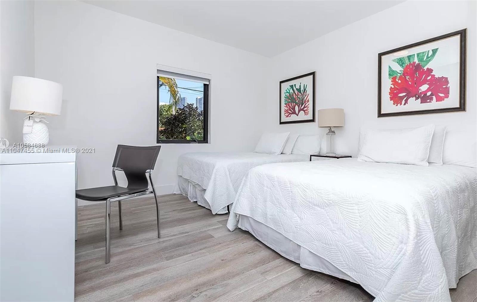 332 Southwest 20th Road Miami, FL 33129 - Photo 13 of 23 a bedroom with a bed and a lamp on table with wooden floor