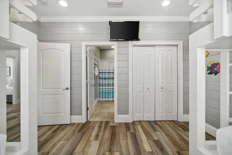 a bedroom with a bed a mirror and a flat tv screen on dresser