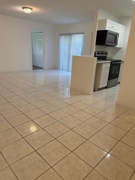 1 Crossing Circle, Unit C Boynton Beach, FL 33435 - Photo 11 of 12 a living room with a couch and a flat screen tv
