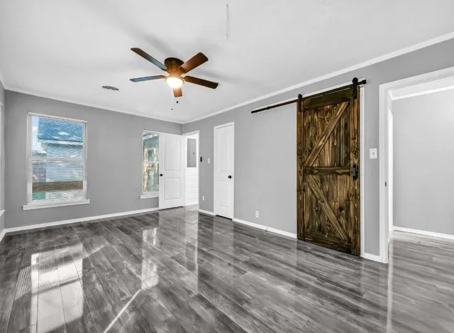 a view of an empty room with window and a ceiling fan