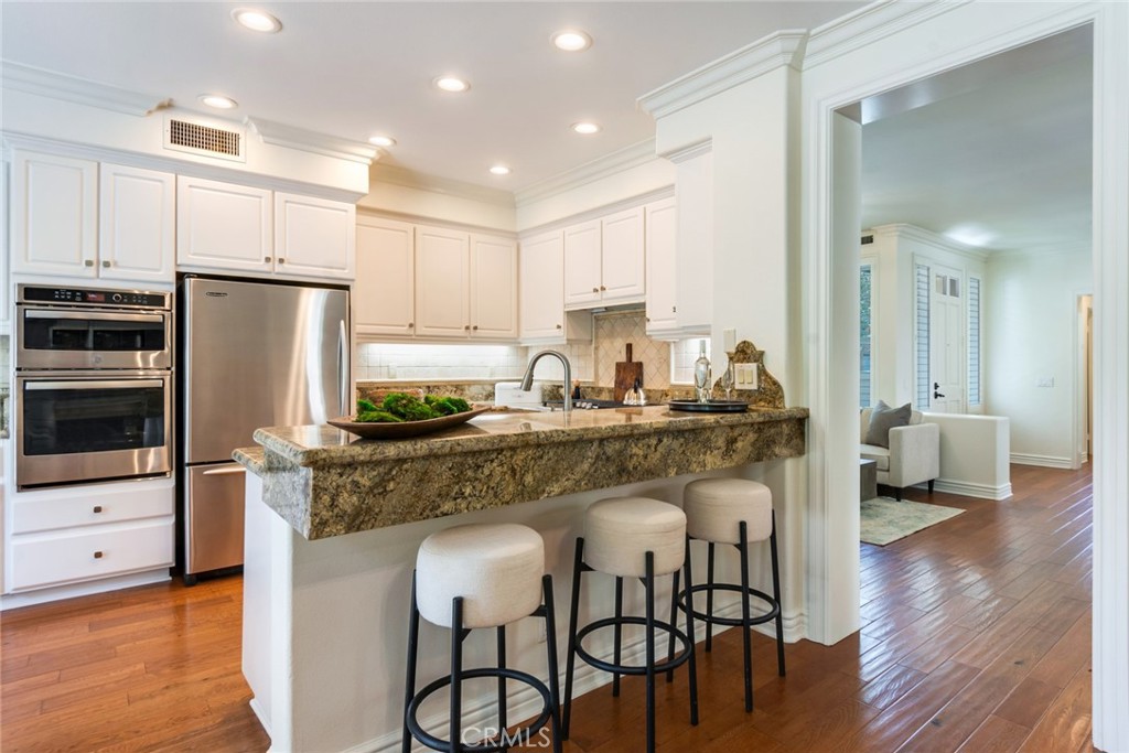 2515 Lewis Drive Tustin, CA 92782 - Photo 11 of 34 a kitchen with stainless steel appliances granite countertop a table chairs stove microwave and cabinets