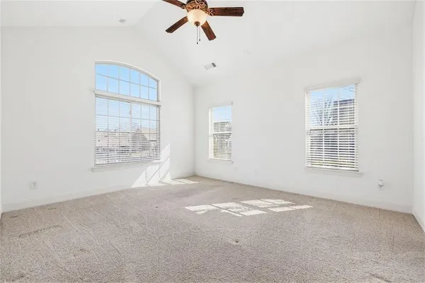 an empty room with fan and windows