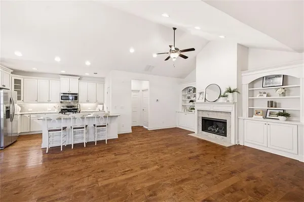 a kitchen with stainless steel appliances wooden floor dining table and chairs