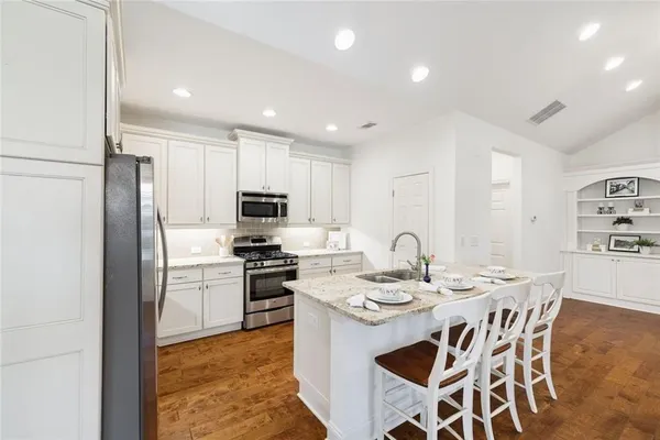 a view of kitchen with granite countertop cabinets and refrigerator