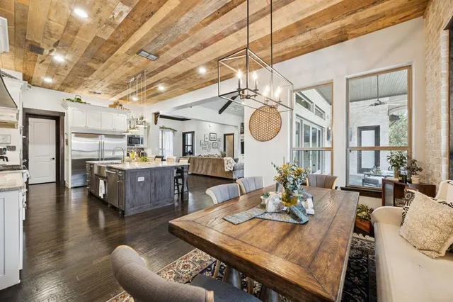 a living room with furniture kitchen view and a chandelier