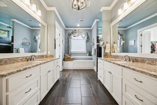 a bathroom with a granite countertop double vanity sink and a large mirror