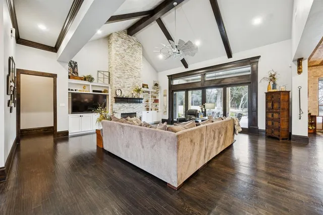 a living room with couches and a flat screen tv with kitchen view