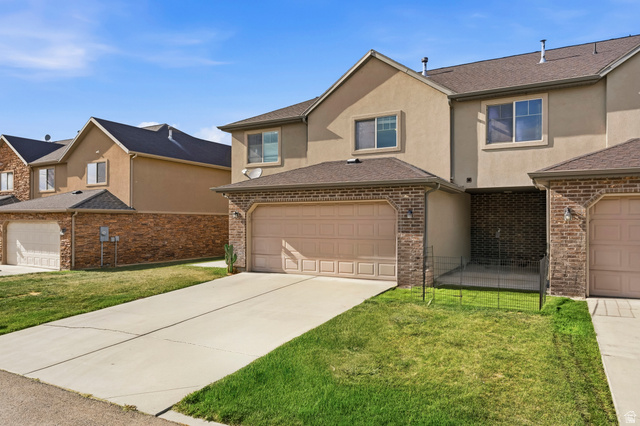 1165 West 100 South Springville, UT 84663 - Photo 15 of 28 Traditional-style house with stucco siding, a front yard, concrete driveway, and brick siding