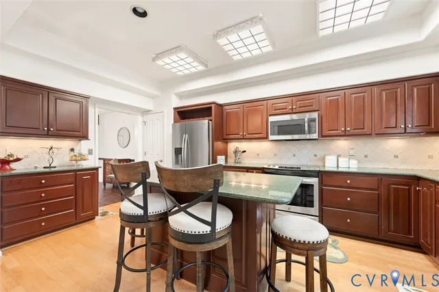 a kitchen with granite countertop wooden cabinets and stainless steel appliances