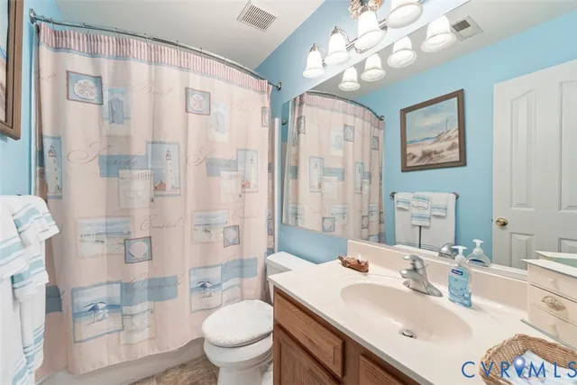 a bathroom with a sink vanity granite toilet and shower