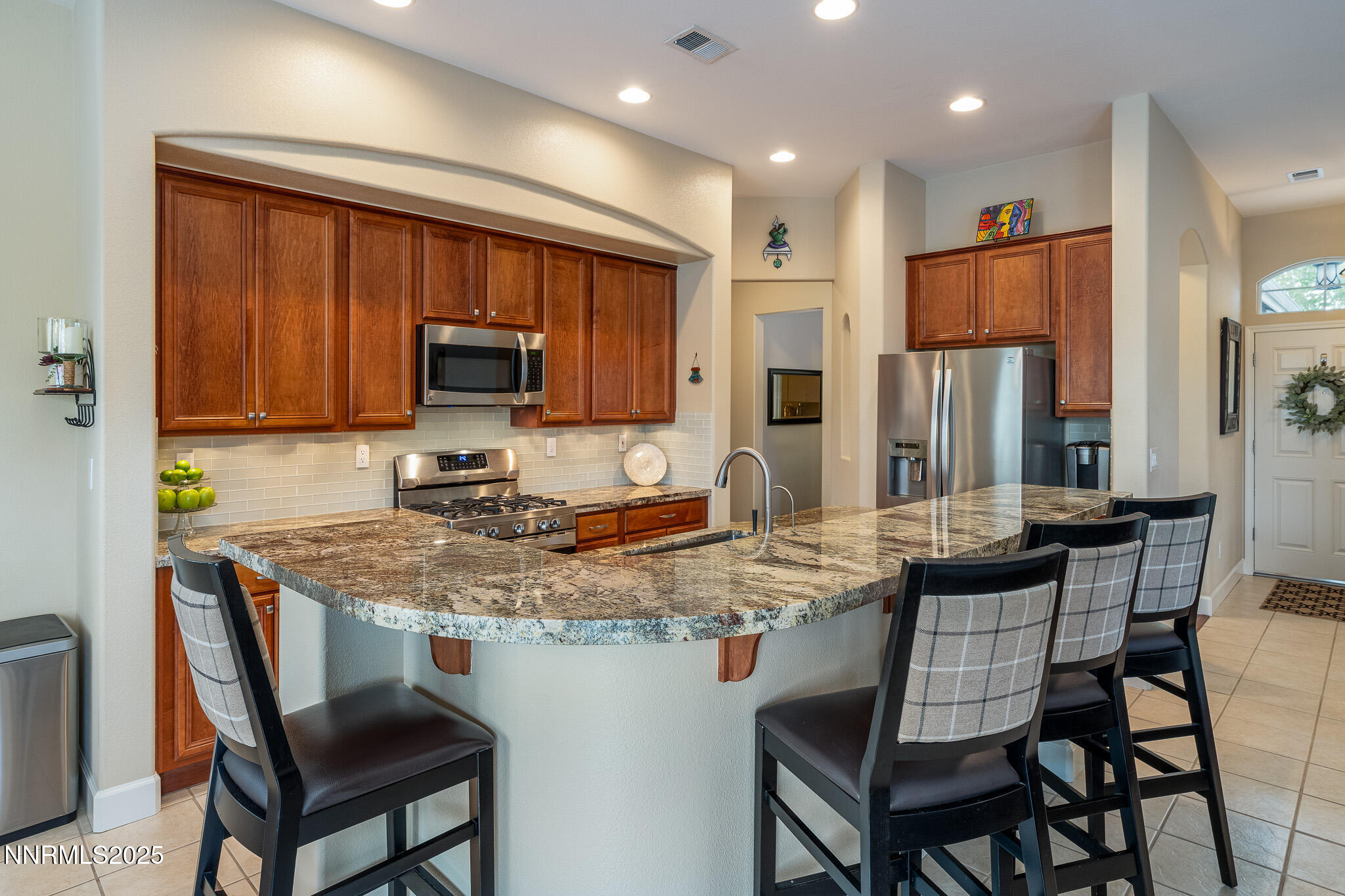 10600 Blue Moon Court Reno, NV 89521 - Photo 4 of 36 a kitchen with stainless steel appliances granite countertop a stove a sink a microwave a refrigerator and chairs