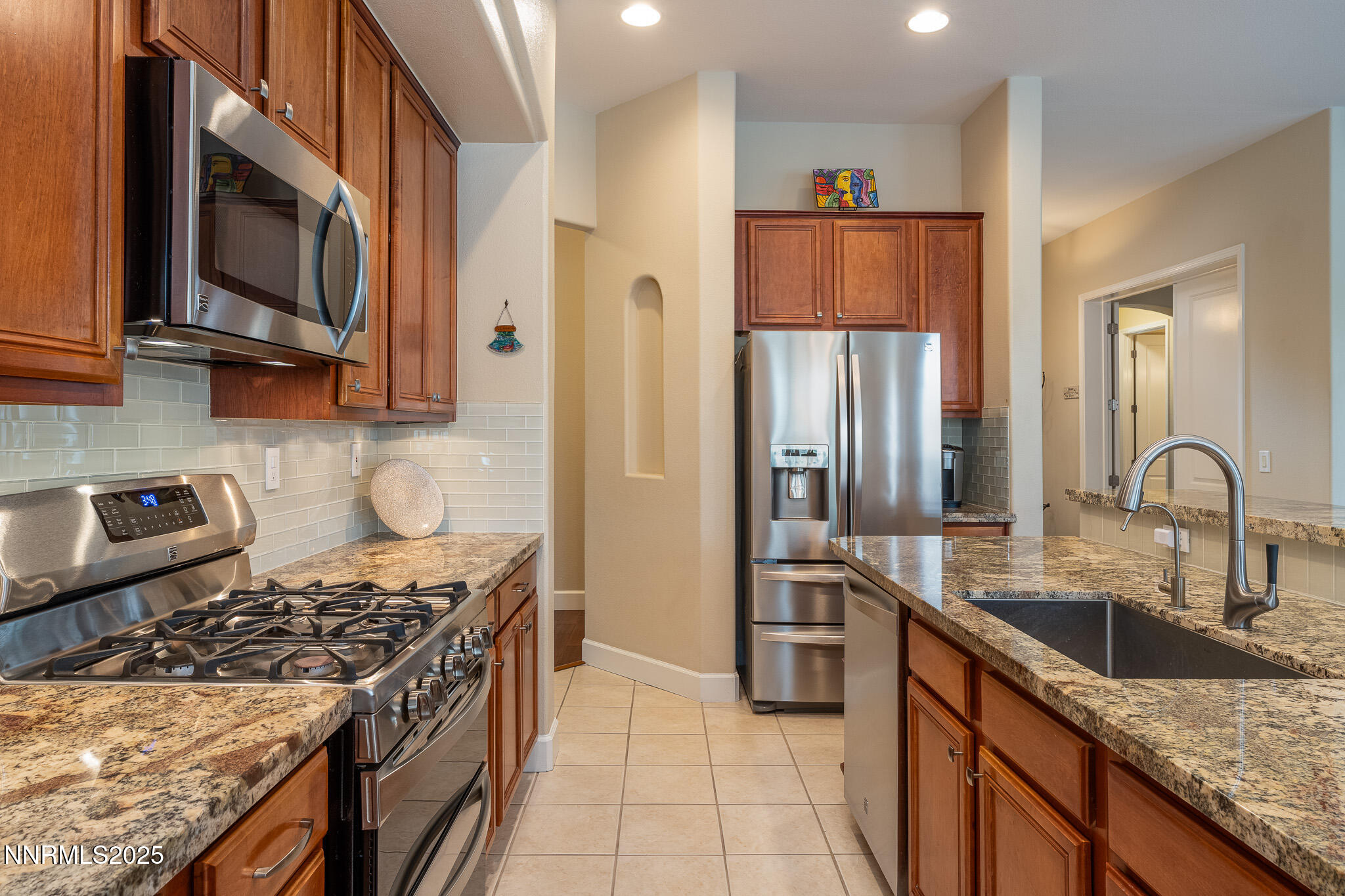 10600 Blue Moon Court Reno, NV 89521 - Photo 5 of 36 a kitchen with stainless steel appliances granite countertop a stove a sink and a microwave