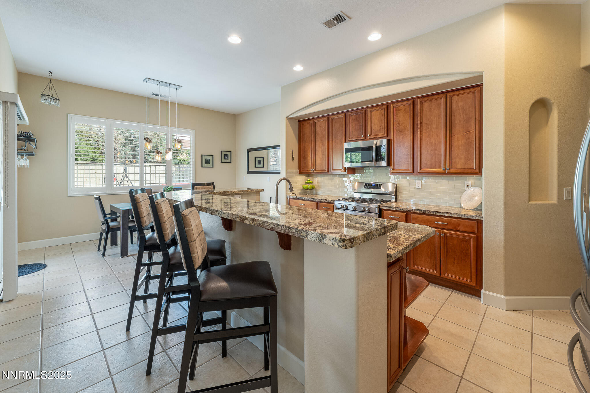10600 Blue Moon Court Reno, NV 89521 - Photo 6 of 36 a kitchen with a dining table chairs and refrigerator