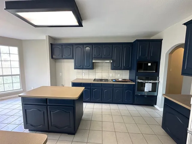 a kitchen with stainless steel appliances granite countertop wooden cabinets a stove a sink and dishwasher