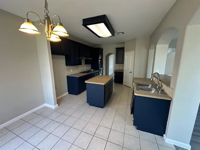 a kitchen with a sink cabinets and wooden floor