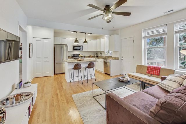 a living room with stainless steel appliances granite countertop furniture and a view of kitchen