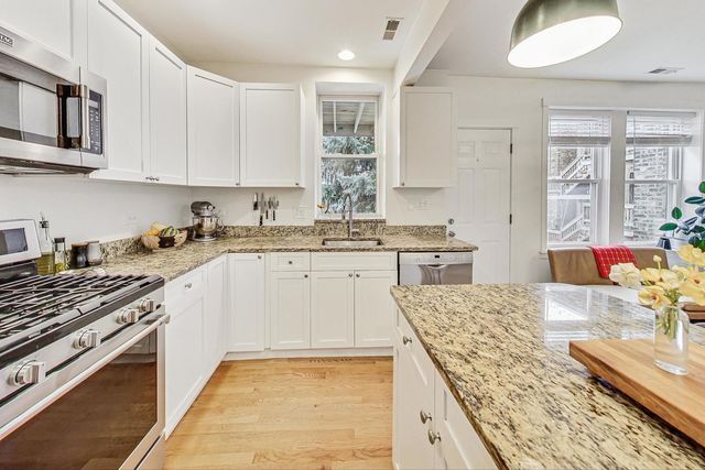 a kitchen with stainless steel appliances granite countertop a sink stove and cabinets