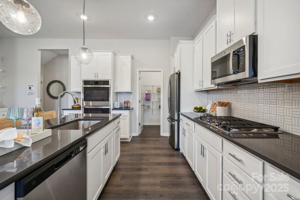 8661 Miles Gap Road Indian Land, SC 29707 - Photo 12 of 31 a large kitchen with stainless steel appliances granite countertop a stove a sink and a microwave