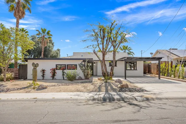 a front view of a house with a tree