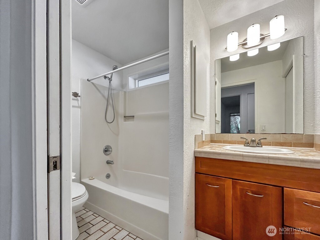 7571 Old Redmond Road, Unit 7 Redmond, WA 98052 - Photo 15 of 17 a bathroom with a granite countertop sink a toilet and shower