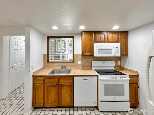 a kitchen with sink a stove and microwave