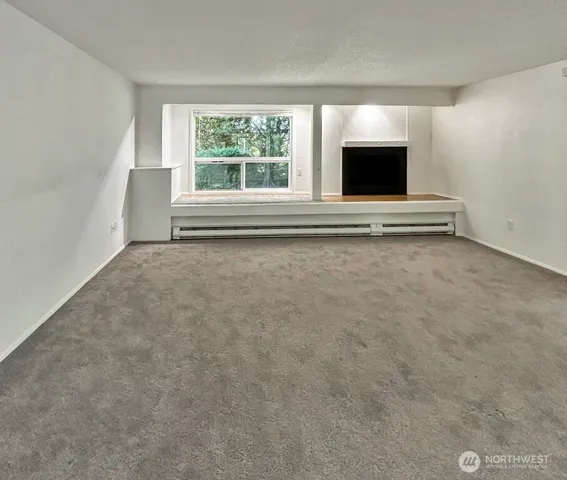 a view of an empty room with a fireplace and a flat screen tv