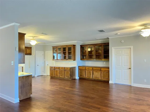 a large living room with a large window and wooden floor