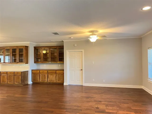 a view of a livingroom with wooden floor and a large window