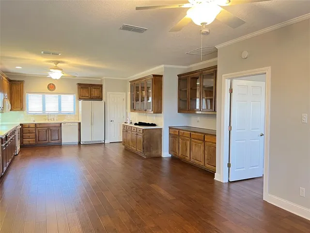a view of a kitchen with a sink stove cabinets and empty room