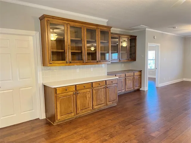 a large white kitchen with stainless steel appliances granite countertop a sink and wooden floors