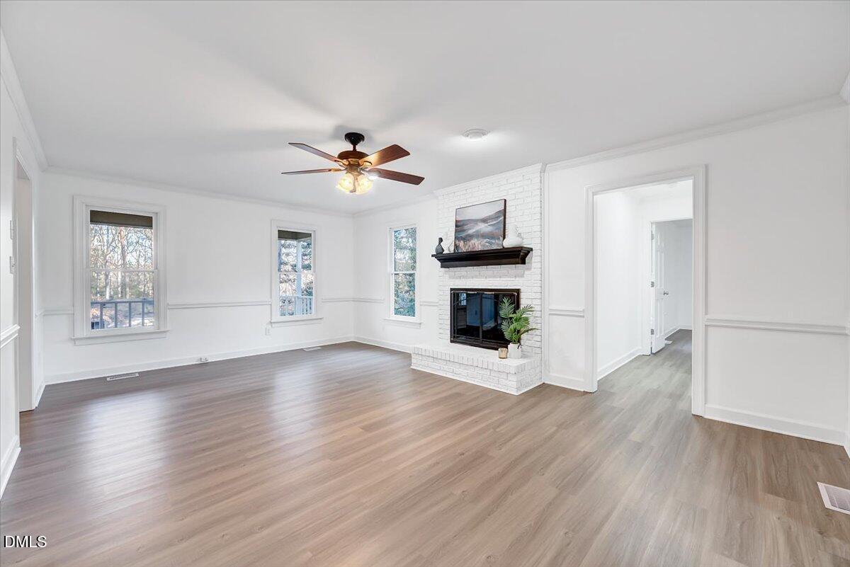 1208 Turner Farms Road Garner, NC 27529 - Photo 4 of 38 a view of a livingroom with a fireplace a ceiling fan and wooden floor