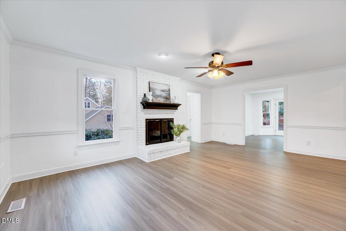 1208 Turner Farms Road Garner, NC 27529 - Photo 9 of 38 a view of an empty room with wooden floor and a fireplace
