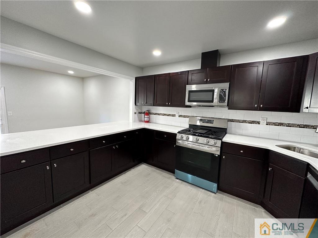 3703 Hana Road Edison, NJ 08817 - Photo 17 of 55 a kitchen with a sink stove and microwave