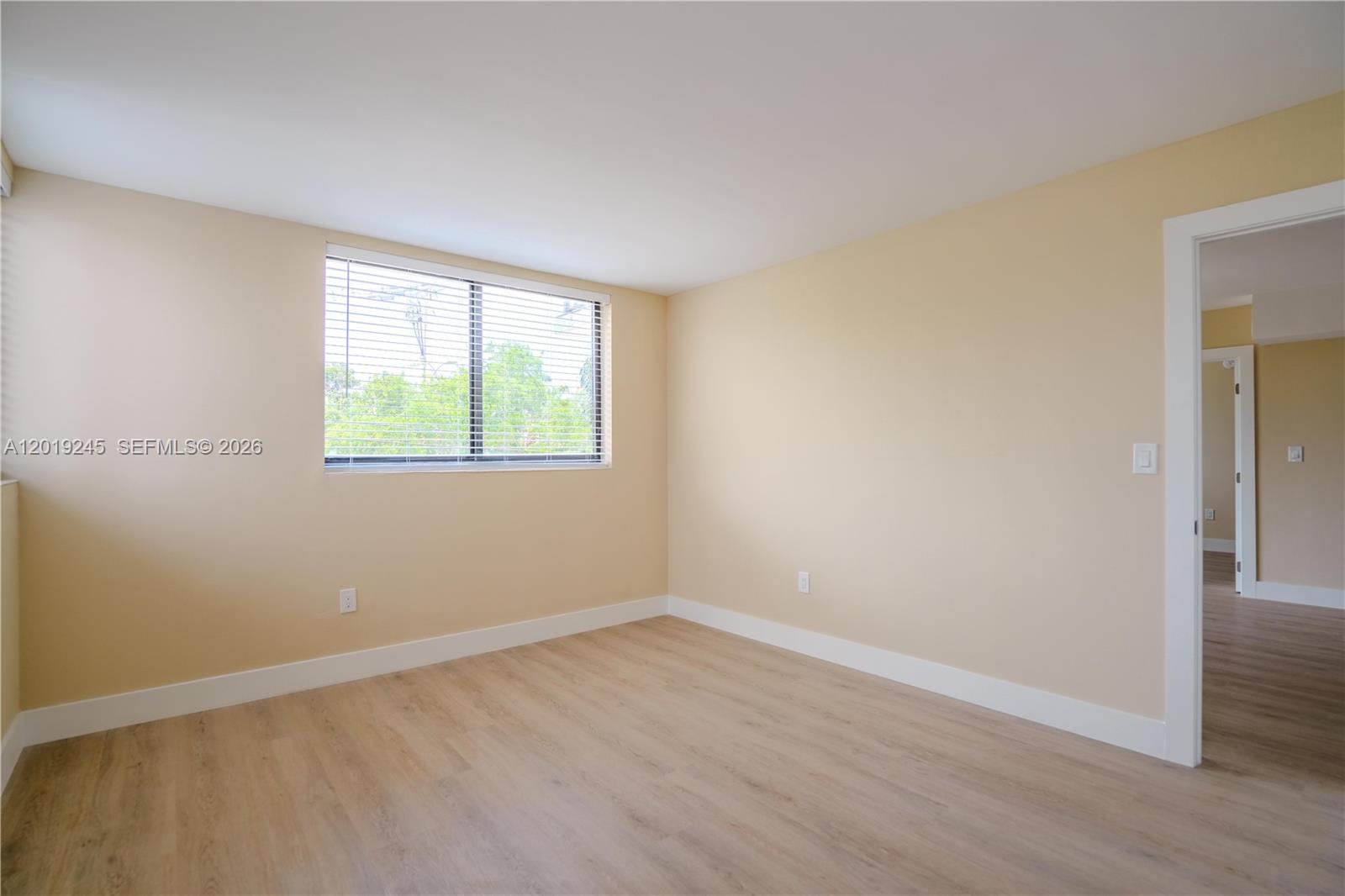 6960 Rue Vendome, Unit 201 Miami Beach, FL 33141 - Photo 11 of 27 an empty room with wooden floor and windows
