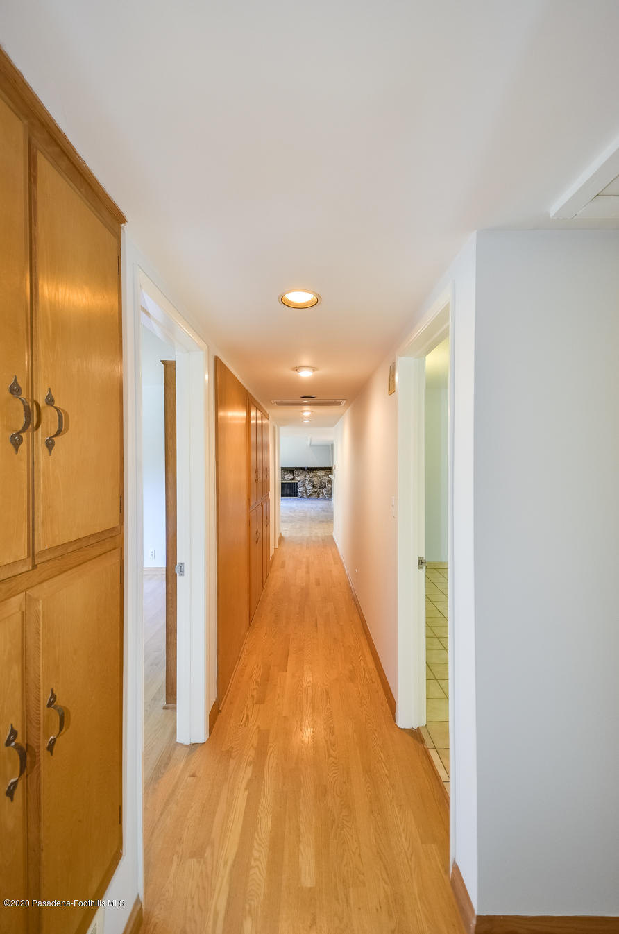 588 Glen Holly Drive Pasadena, CA 91105 - Photo 13 of 31 a view of a hallway with wooden floor and a bathroom