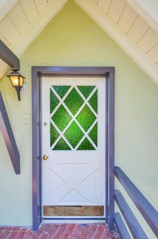 an empty room with wooden floor a fireplace and windows